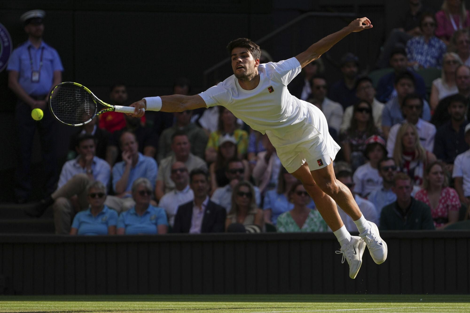 Britain's Cameron Norrie returns to Spain's Carlos Alcaraz during a quarterfinal men's singles match at the Wimbledon Tennis Championships in London, Tuesday, July 8, 2025. (AP Photo/Kirsty Wigglesworth). EDITORIAL USE ONLY/ONLY ITALY AND SPAIN