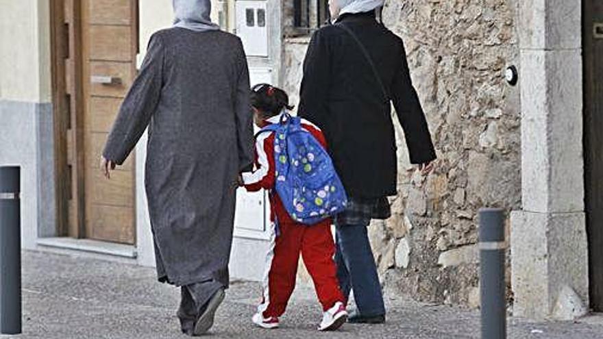 Una nena va a classe acompanyada de dues dones musulmanes.