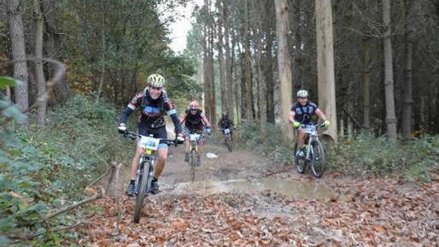 Un grupo de deportistas cruza un charco en una pista.