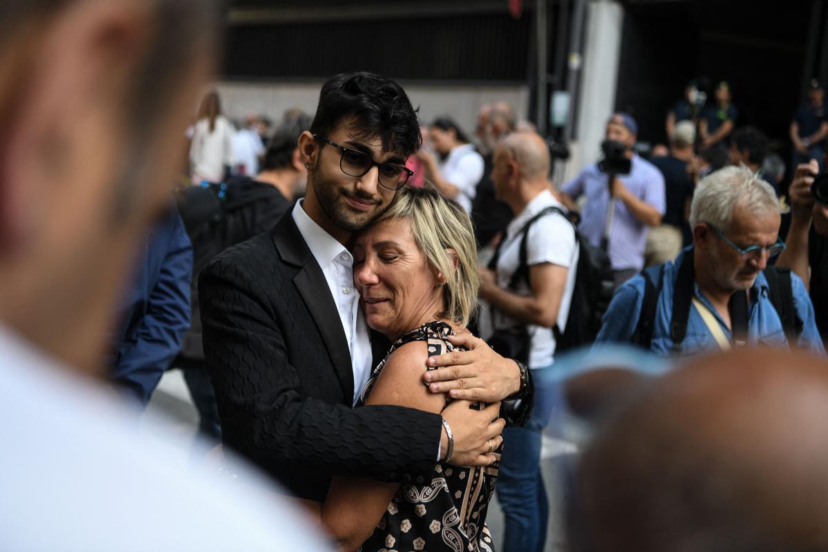 Michele Mattia Altadonna y Paola Vicini, familiares de las víctimas del derrumbe del puente Morandi en Génova, se abrazan en el juicio de la tragedia.