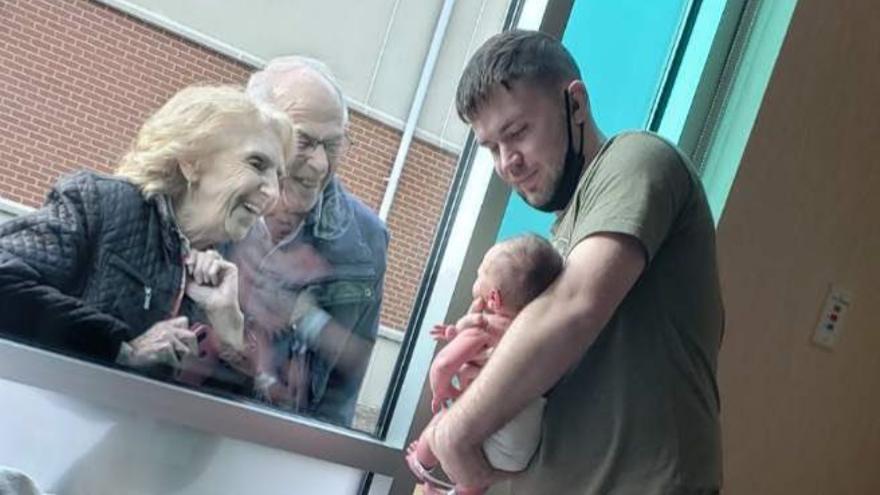 La tierna imagen de unos abuelos conociendo a su nieto recién nacido a través de una ventana