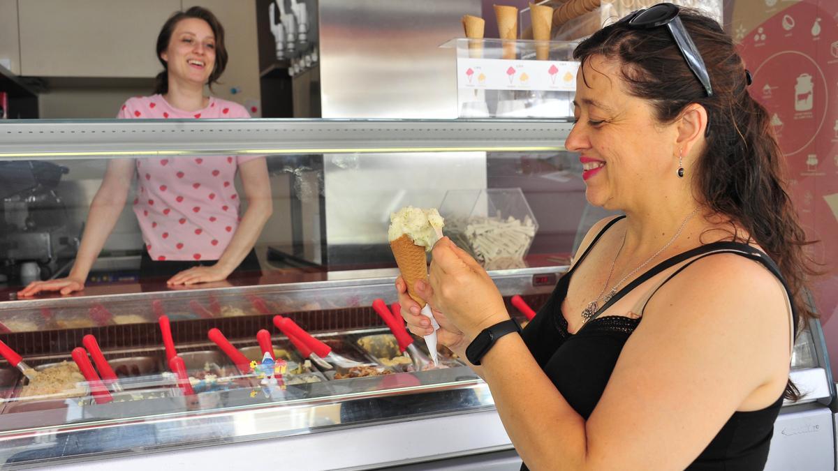 Una mujer se refresca con un helado en un local de Elche