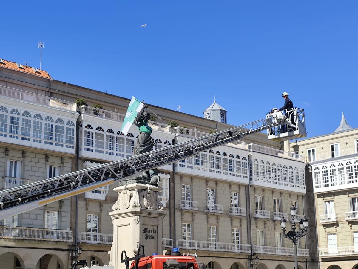 Bomberos colocan la bandera y la camiseta del Liceo que lucirá la estatua de María Pita estos días.
