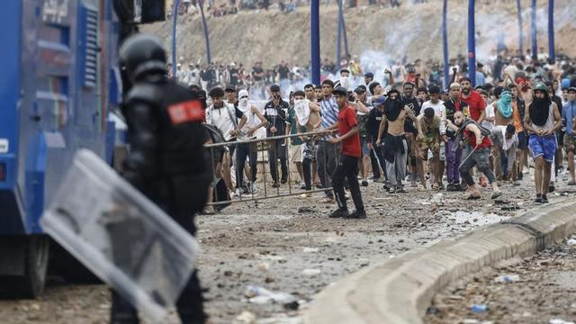 Forces de seguretat marroquines s’enfronten a Castillejos amb persones que intenten passar a Ceuta. | ABDEL MAJID BZIOUAT / AFP
