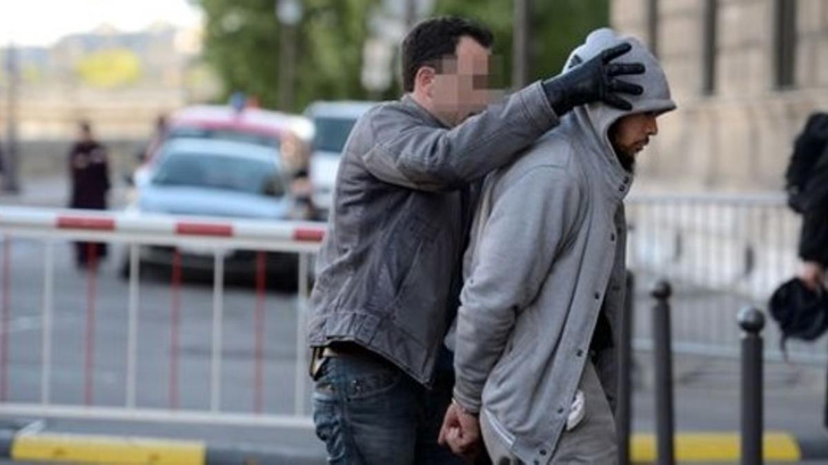 Un agente antiterrorista escolta al detenido por el ataque a un militar francés, este miércoles, en la localidad de La Verrière.