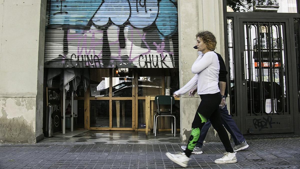 Un comercio del barrio de Sant Antoni de Barcelona con la persiana medio bajada, el 14 de abril