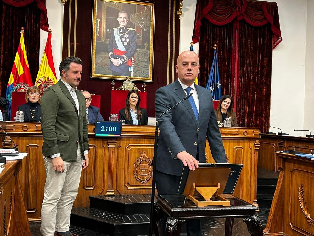 Miguel Serna tomando posesión como concejal en el pleno de este lunes, con el alcalde, Pablo Ruz, al fondo.