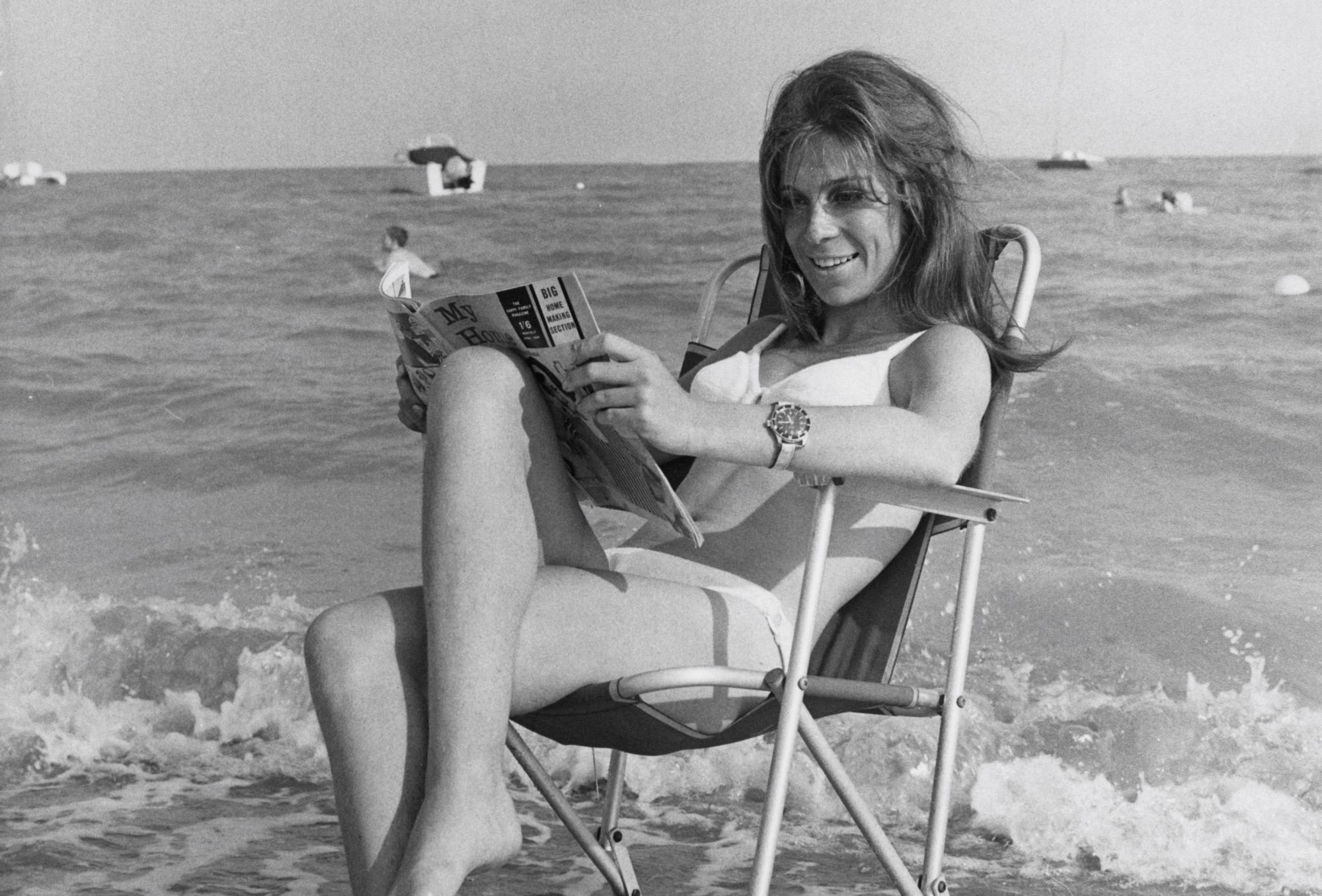 La actriz Sandra Bryant leyendo en la playa