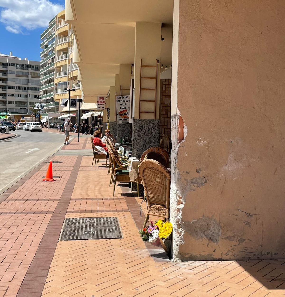 Flores depositadas en una de las columnas de la terraza de la pizzería del paseo marítimo de Fuengirola, en la que se produjo el atropello mortal, en el que murieron dos personas