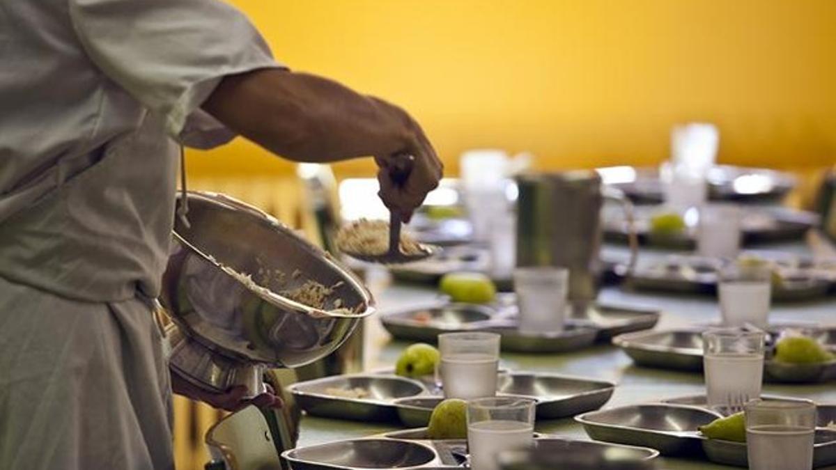 Una monitoria del comedor escolar llena las bandejas de los alumnos del colegio Ramon Llul de Barcelona, en septiembre pasado