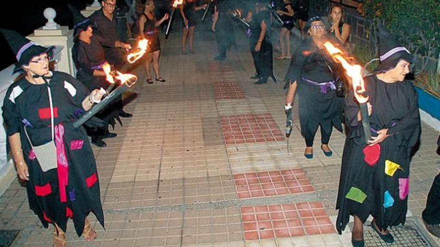 Grupo de mujeres ataviadas como brujas, anoche, en la representación de &#039;Los Mechones&#039;, en el paseo que une Salinetas con Melenara.