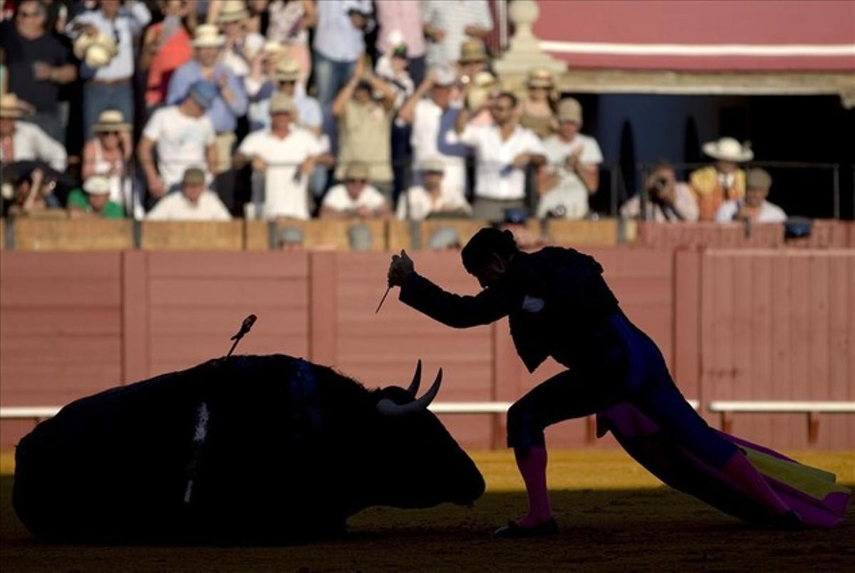 Un torero dóna el cop de gràcia a un toro durant una corrida de toros a la plaça de toros de la Maestranza de Sevilla