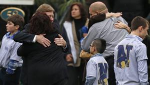 Diverses famílies s’abracen amb nens que porten samarretes de Newtown.