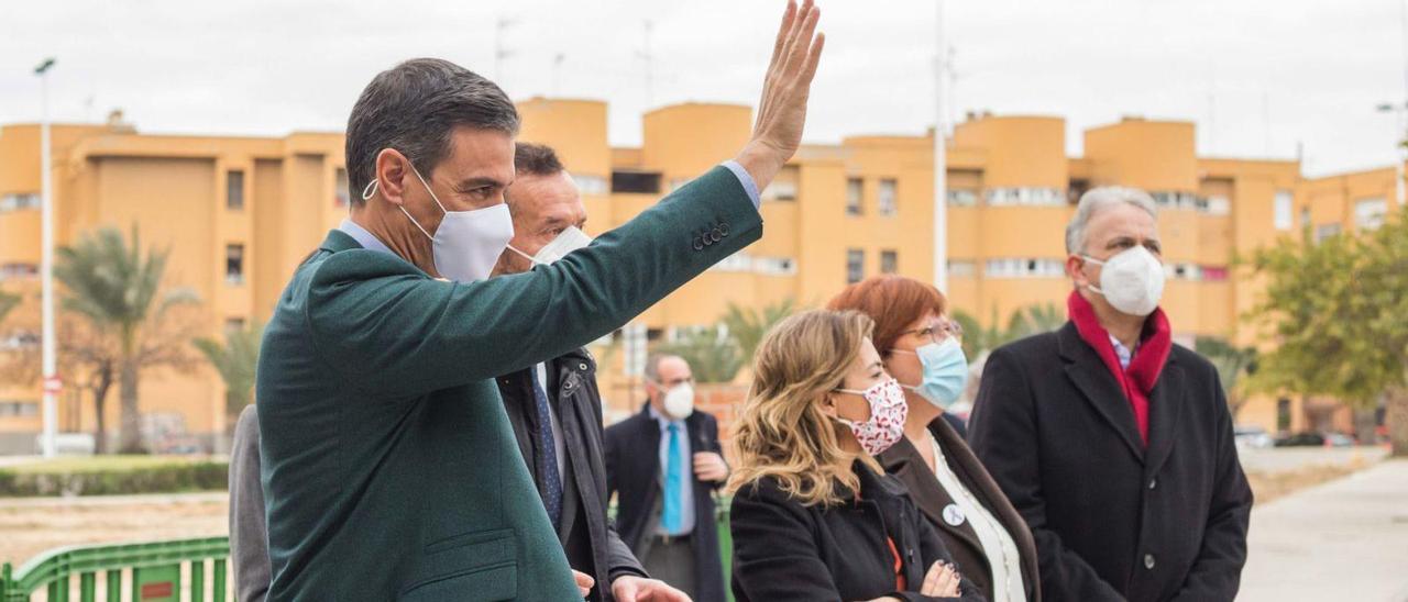 Sánchez a su llegada al barrio San Antón, saludando a los vecinos, junto al alcalde y la ministra de Agenda Urbana, con Los Palmerales al fondo. | ANTONIO AMORÓS