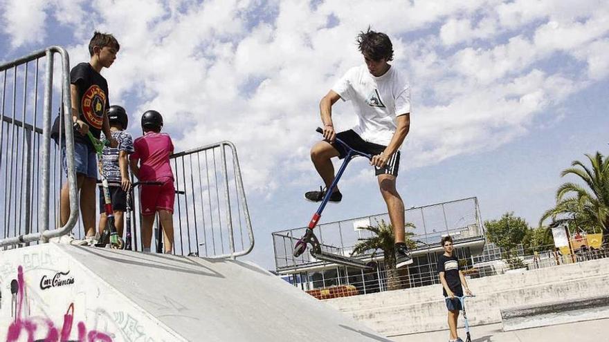 Unos niños realizan piruetas con sus monopatines en la pista de skate del Parque Azul. // Santos Álvarez