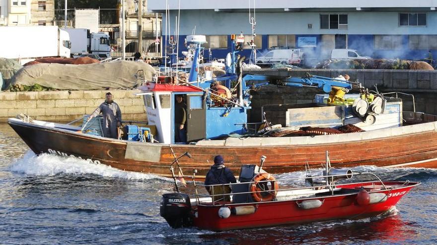 Un cerquero de la ría de Vigo pasa junto a una planeadora en una fotografía del año pasado. // Alba Villar