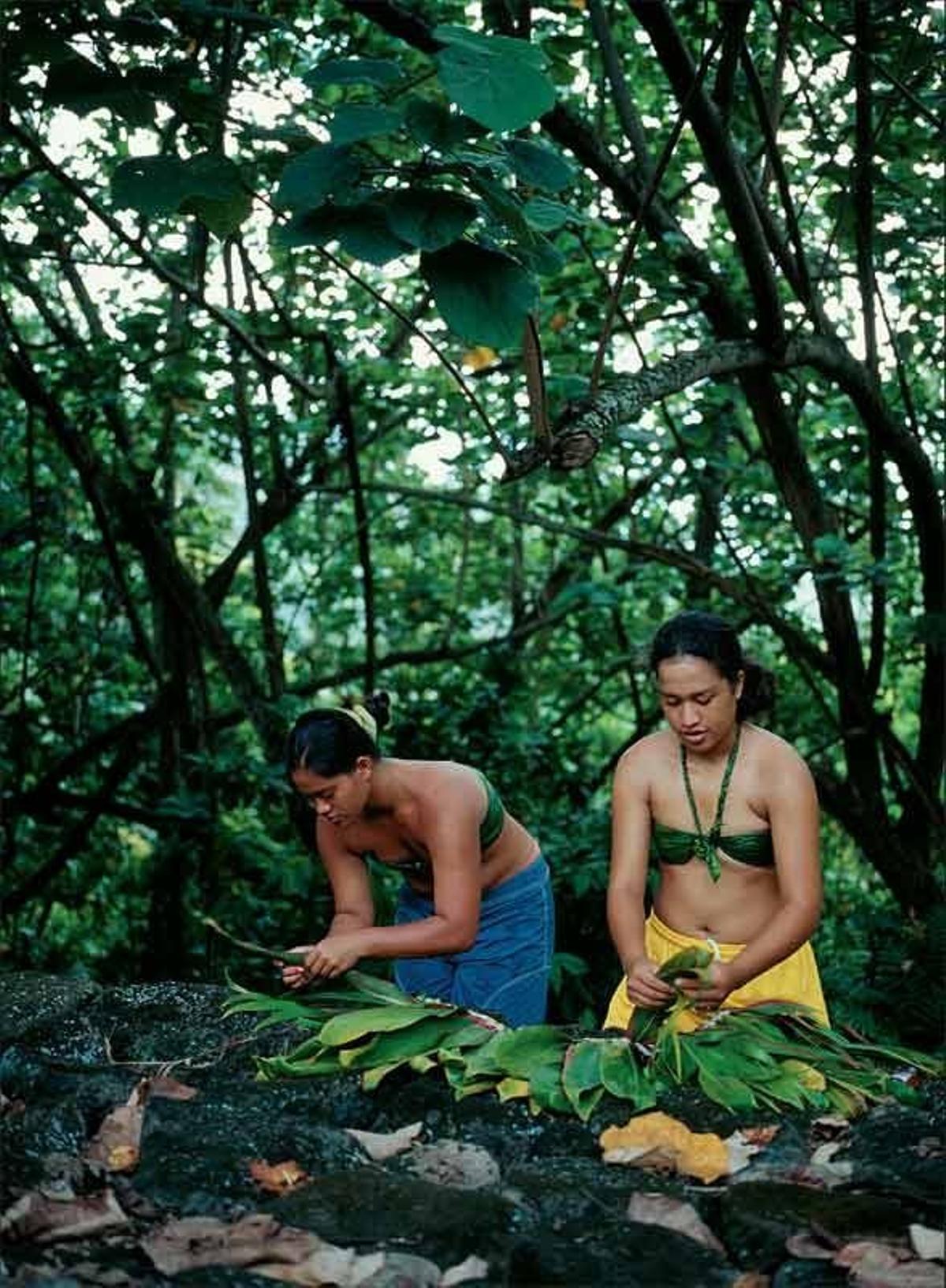 Dos mujeres preparan adornos florales en la isla de Nuku Hiva.