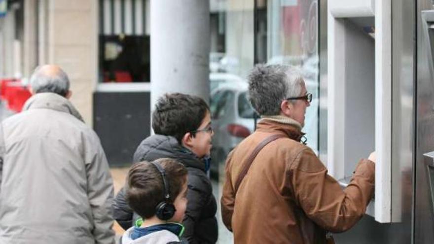 Una mujer realiza operaciones en un cajero automático, en Vigo.  // Jesús de Arcos