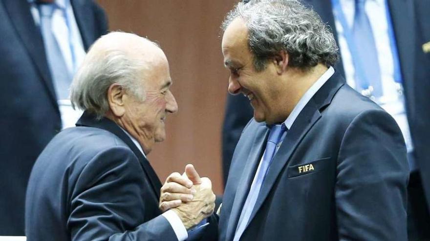 Blatter y Platini se saludan durante una reunión de la FIFA.