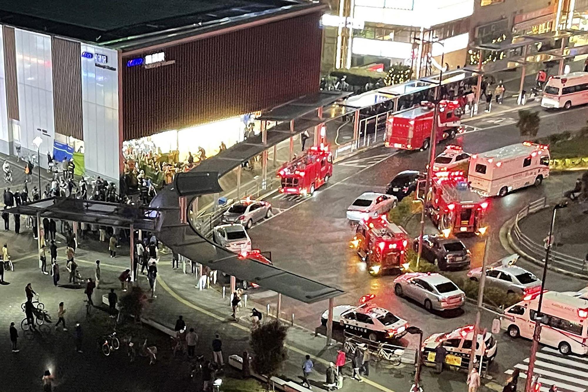 bomberos y rescatistas reunidos frente a la estación Kokuryo en la línea Keio en la ciudad de Chofu, en el oeste de Tokio, el 31 de octubre de 2021