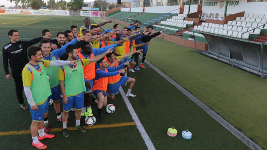 Los jugadores de la Peña señalan a la grada del campo de Santa Eulària, que esperan que se llene el domingo.