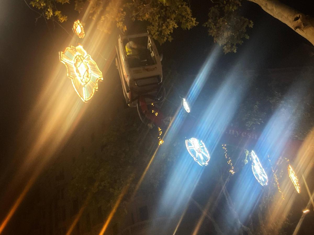 Un operario en grúa comprueba las nuevas luces de Navidad de la avenida Diagonal, en Barcelona.