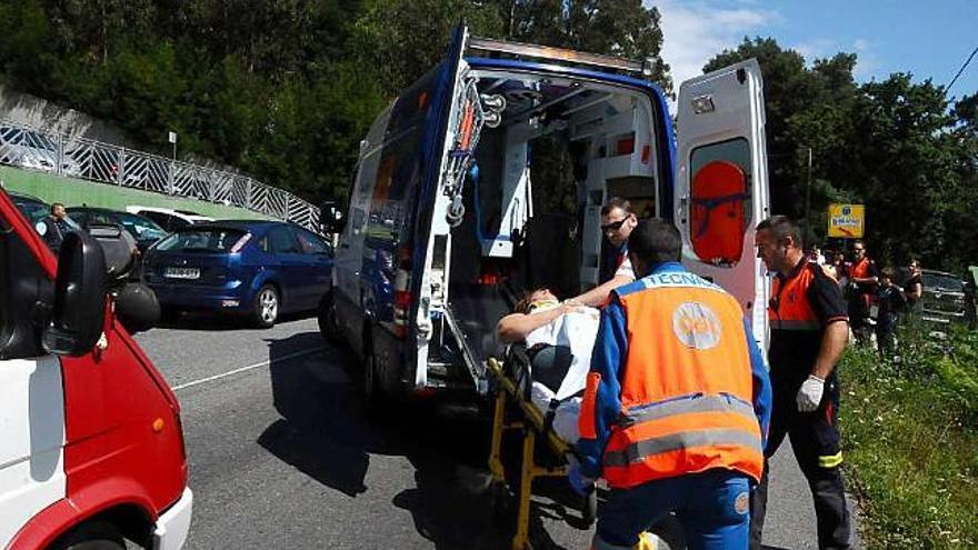 Personal del 061 atiende a uno de los heridos en el accidente registrado ayer en Cangas. / gonzalo núñez