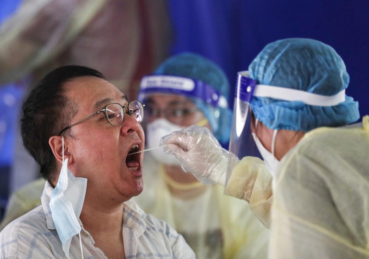 20/07/2020 20 July 2020, China, Hong Kong: AÂ medical worker takes a swab from a taxi driver at a makeshift testing station for coronavirus (Covid-19) in a carpark. Photo: May James/SOPA Images via ZUMA Wire/dpa