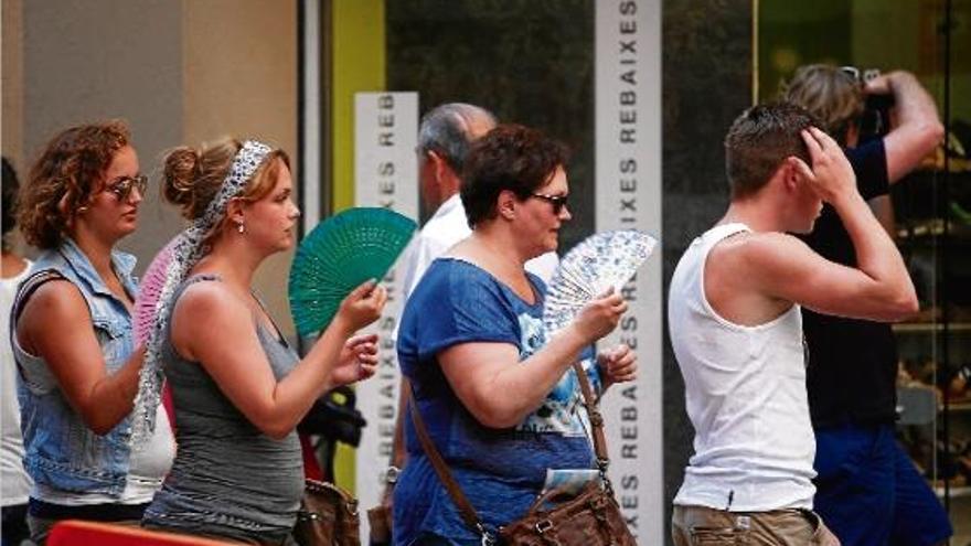 Turistes al Barri Vell de Girona fent front a les altes temperatures concentrades en dues onades de calor durant el juliol.