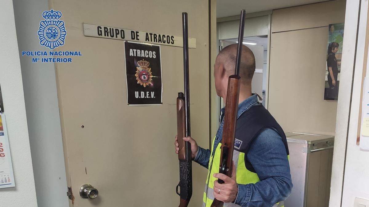 Un policía sostiene la escopeta de caza y el rifle que portaba el tirador.