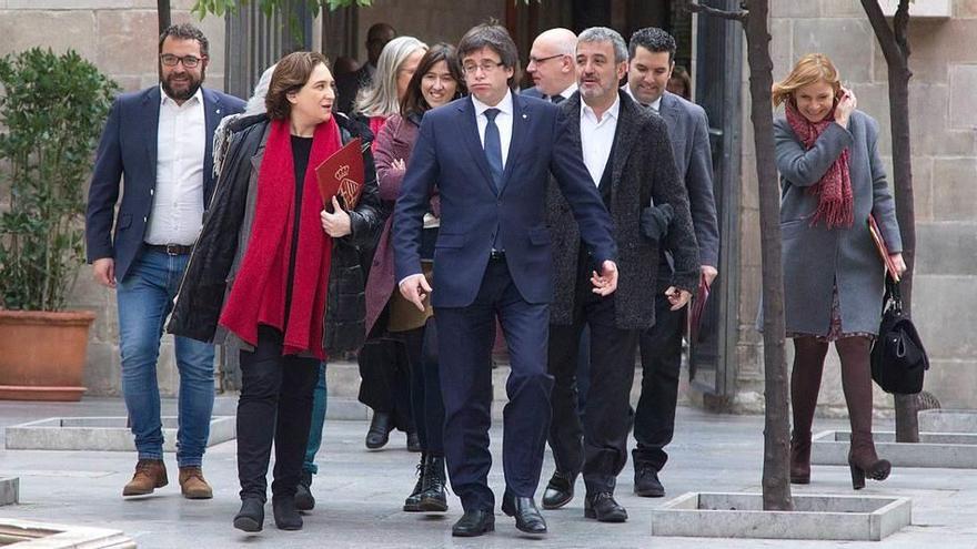 El presidente de la Generalitat, Carles Puigdemont (en el centro), y la alcaldesa de Barcelona, Ada Colau, en un acto ayer en Barcelona.