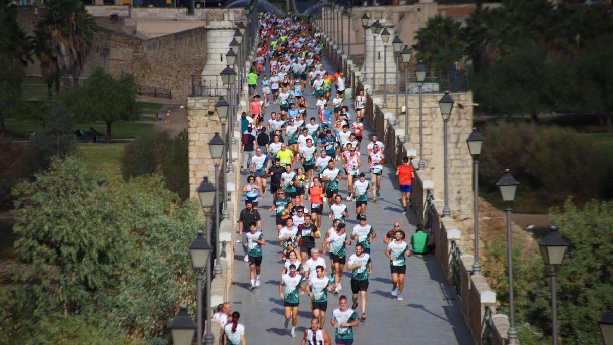 Los corredores cruzan el puente de Palmas en el cross solidario de la Guardia Civil de Badajoz, el año pasado.