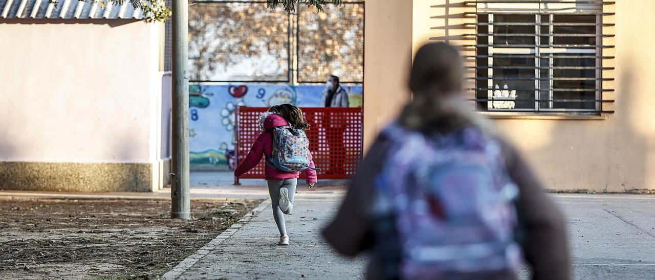 Dos niños entrando en un colegio.