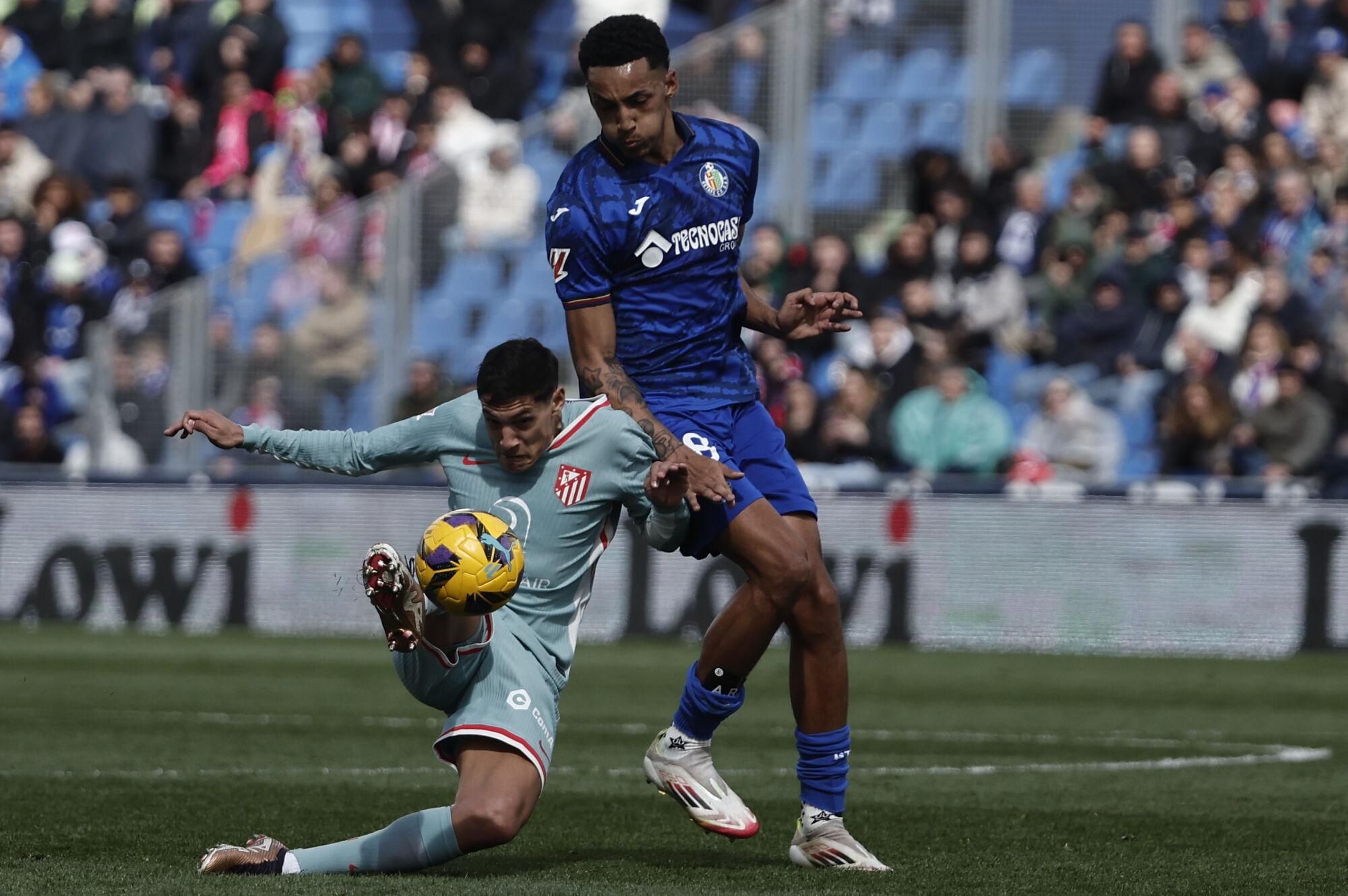 GETAFE (MADRID), 09/03/2025.- El defensa del Atlético de Madrid Nahuel Molina (i) se enfrenta al delantero del Getafe Alvaro Rodriguez (d), durante el partido de la jornada 27 de Liga que disputan este domingo en el estadio Colisum de Getafe. EFE/Sergio Peréz