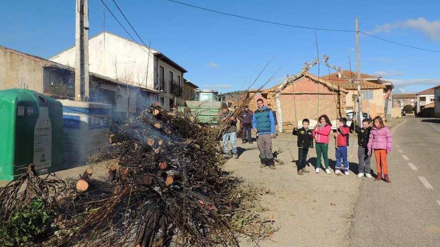 Un grupo de niños de Fuente Encalada ayudan a apilar leña para la fogata de la yera organizada el pasado año.