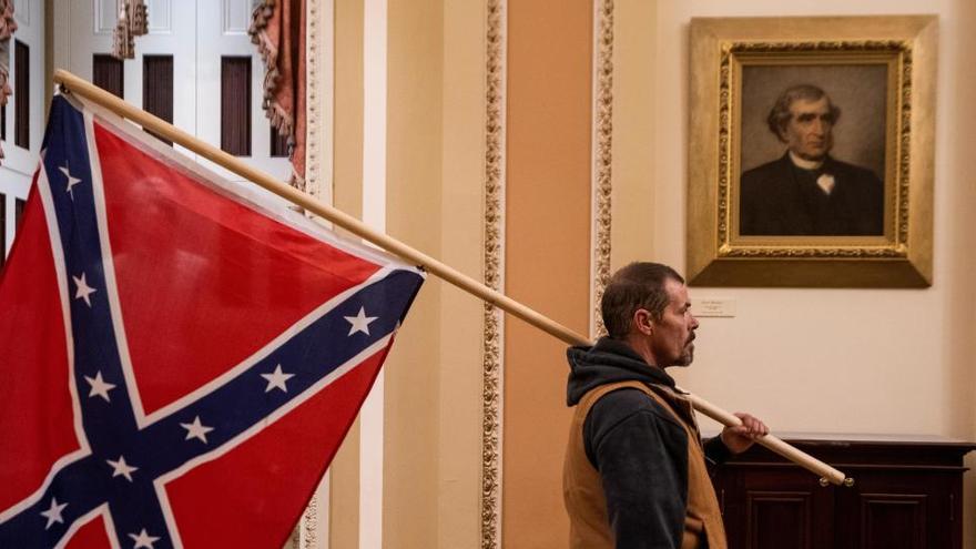 Un manifestante partidario de Trump porta una bandera confederada en el Capitolio.