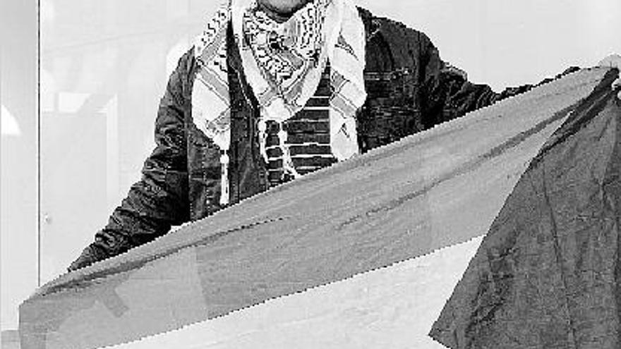 Ayman Talal posa con la bandera de Palestina, ayer en el aeropuerto del Prat.