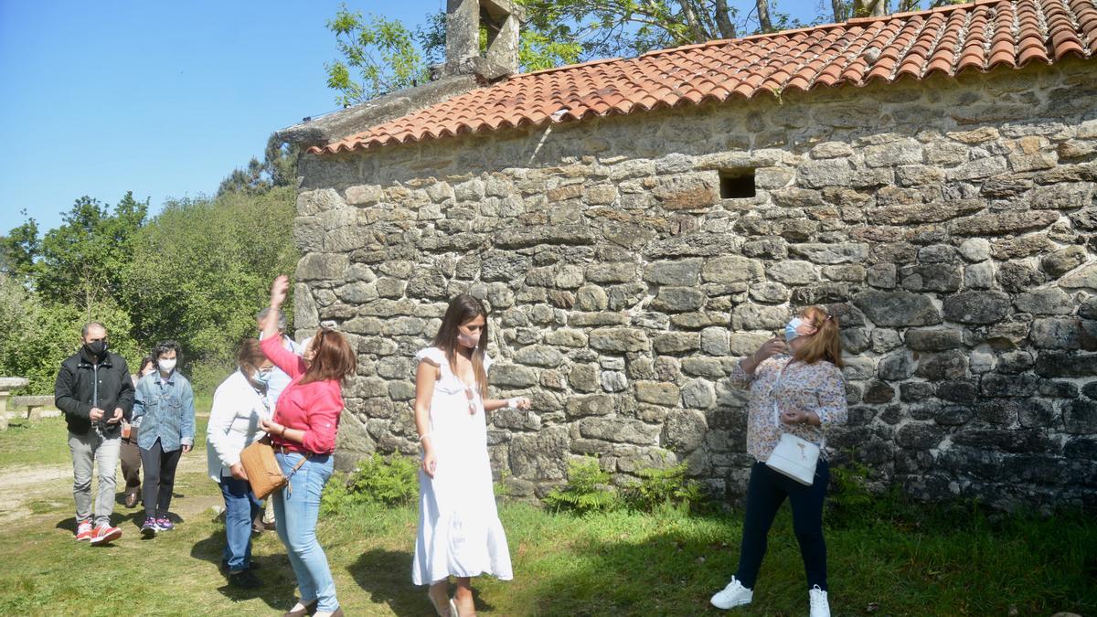 Un grupo de personas cumple el ritual de arrojar piedras sobre el tejado de la ermita de San Cibrán de Tomeza