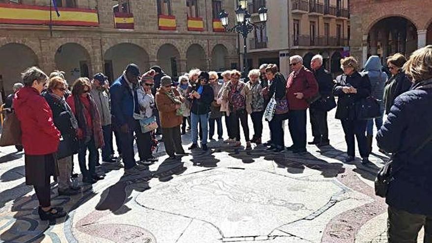 Un grupo de turistas contemplando el mosaico de la Plaza Mayor.