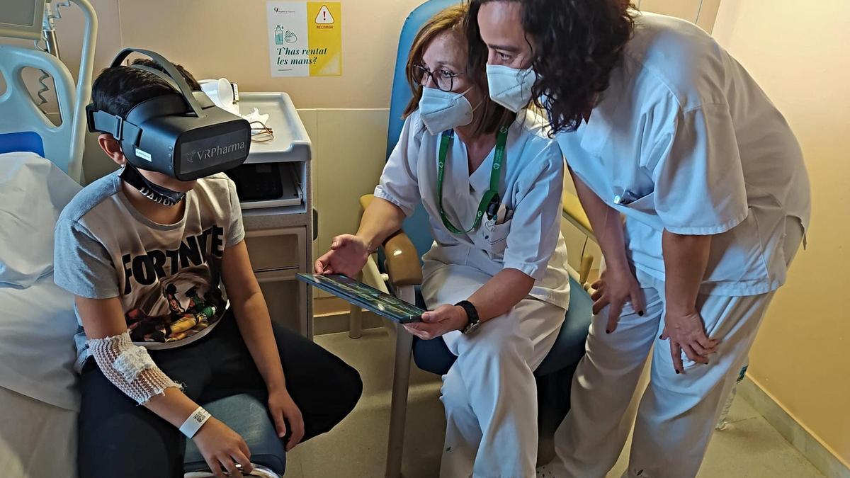Pla general d&#039;un infant utilitzant les ulleres de realitat virtual a l&#039;hospital de Figueres amb dos professionals al costat el 10 de gener de 2022. (Horitzontal)