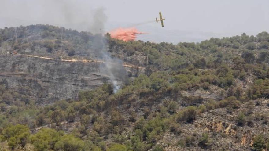 Un hidroavión, ayer, en un foco activo del incendio.