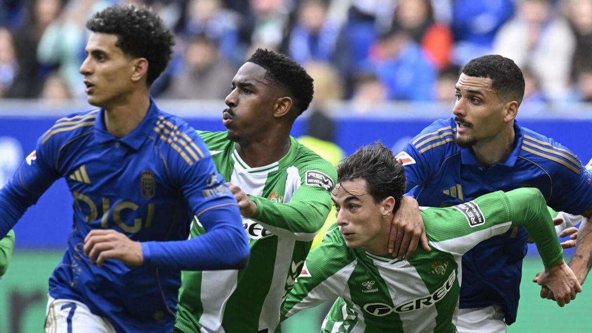 Jugadores del Real Oviedo y el Real Betis pugnan por el balón en un centro lateral.EFE/Eloy Alonso. (OVIEDO) (BETIS)