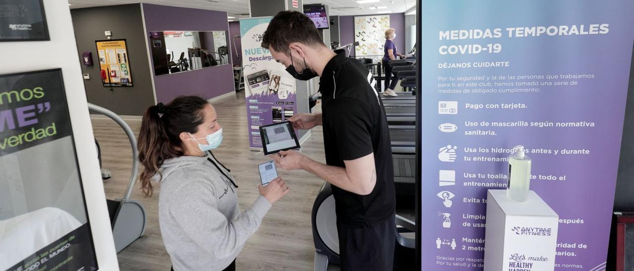 Esta imagen, captada en un gimnasio donde un monitor pide el certificado, pasará a la historia la próxima semana. | MANU MIELNIEZUK