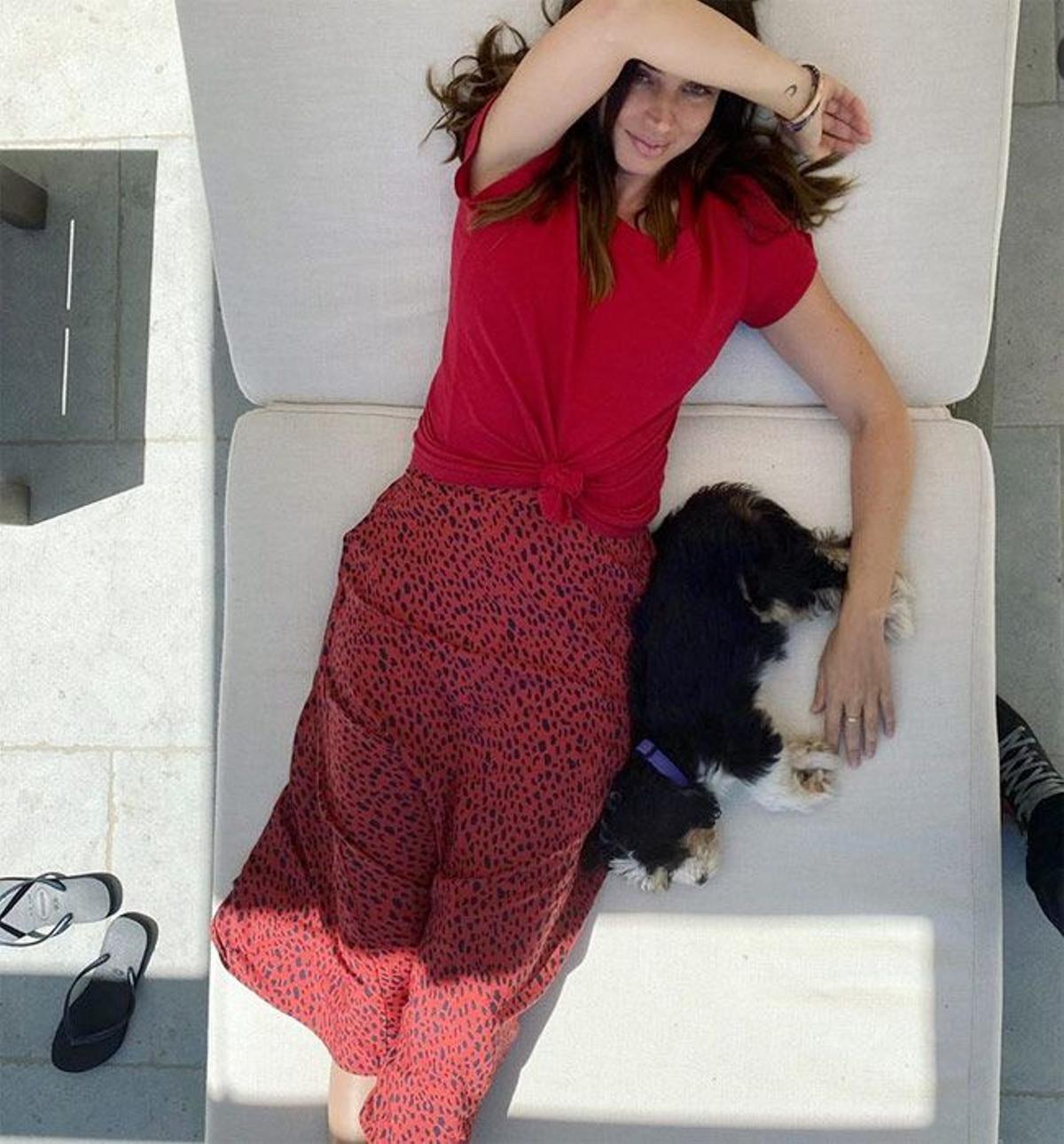 Ana de Armas con 'total look' rojo de camiseta con nudo y falda 'midi' estampada, junto a su perrita Salsa