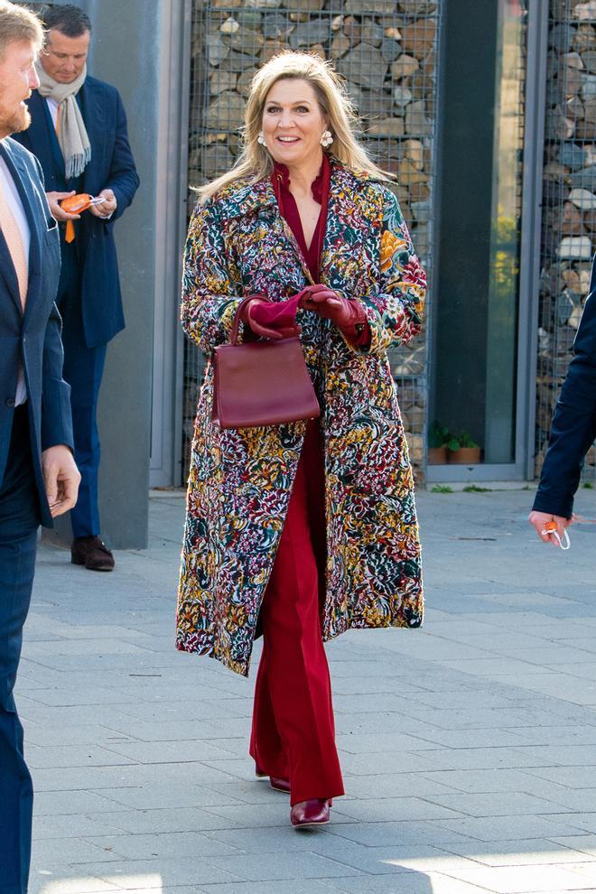 La reina Maxima de Holanda con traje rojo y abrigo estampado de flores