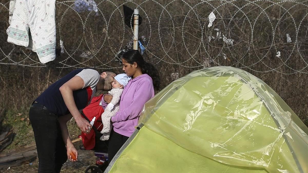 Un migrante besa a un bebé en Pazarkule, cerca de la frontera turco-griega.
