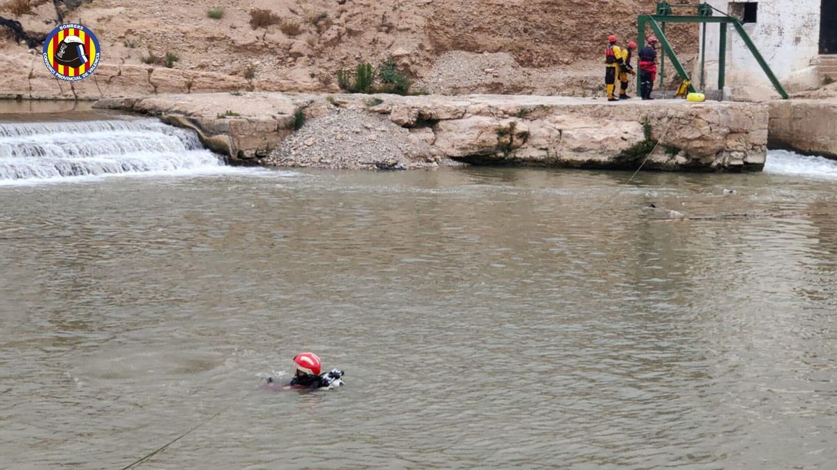 Un bombero realizando labores de búsqueda del joven que ha desaparecido en el río Túria