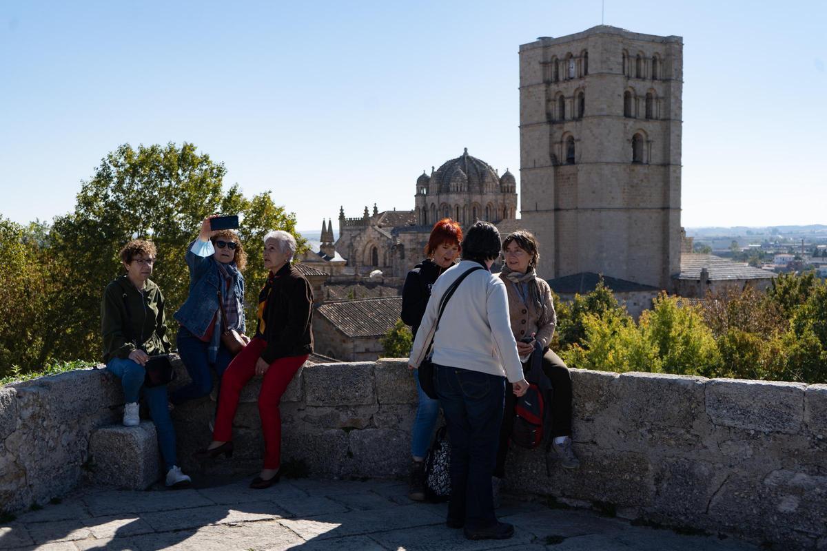 Turistas se fotografían con la Catedral de Zamora de fondo junto a las torres del castillo.