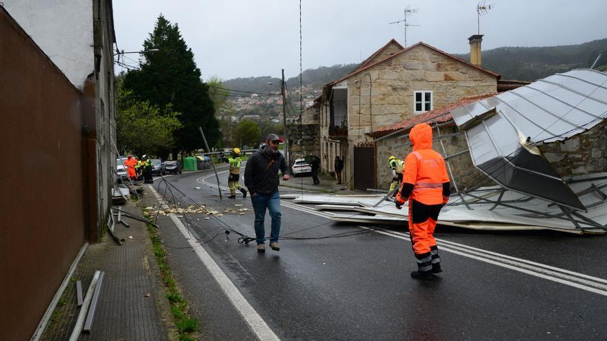 El temporal levanta la cubierta de la Escola de O Con que cayó sobre la carretera general en Domaio