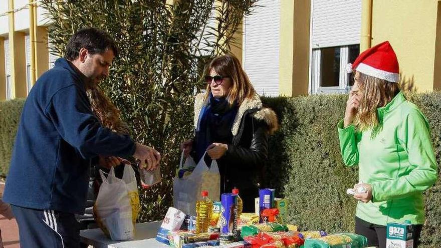 Un padre dona alimentos para participar en las actividades del centro.